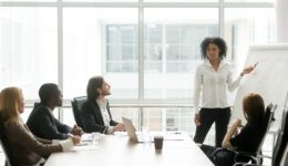 African American Businesswoman Giving Presentation To Executive